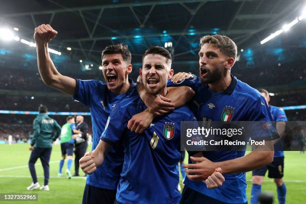 Jorginho of Italy celebrates with Matteo Pessina and Domenico Berardi after scoring their sides winning penalty in the penalty shoot out during the...