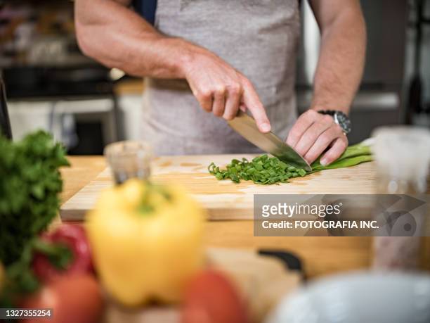 young man cooking italian meal in home kitchen - scallion stock pictures, royalty-free photos & images