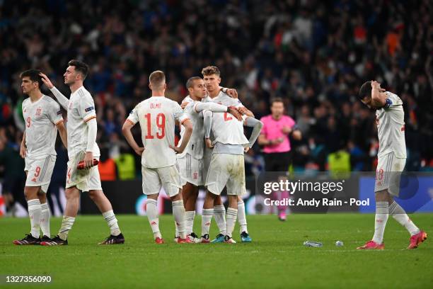 Pedri of Spain is consoled by team mates Thiago Alcantara and Marcos Llorente following defeat in the UEFA Euro 2020 Championship Semi-final match...