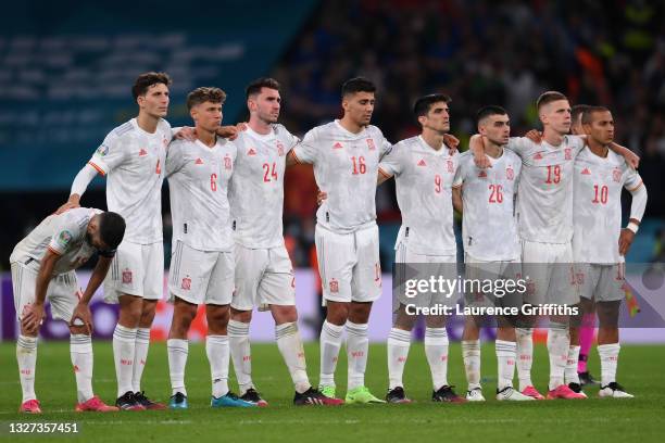 The Spain players look on from the half way line as Alvaro Morata of Spain steps up to take their team's fourth penalty during a penalty shoot out...