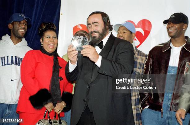 Italian operatic tenor Luciano Pavarotti stands on stage with Michael Green, American singer, songwriter, and pianist Aretha Franklin , Shawn...