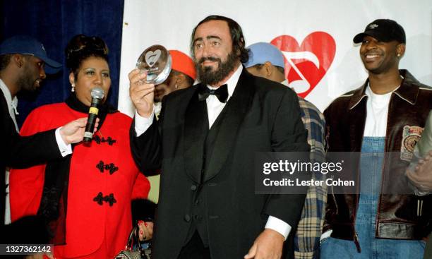 Italian operatic tenor Luciano Pavarotti stands on stage with Michael Green, American singer, songwriter, and pianist Aretha Franklin , Shawn...