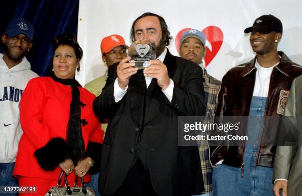 Italian operatic tenor Luciano Pavarotti stands on stage with Michael Green, American singer, songwriter, and pianist Aretha Franklin , Shawn...