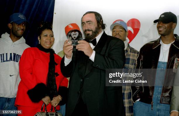 Italian operatic tenor Luciano Pavarotti stands on stage with Michael Green, American singer, songwriter, and pianist Aretha Franklin , Shawn...