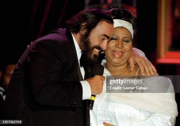 Italian operatic tenor Luciano Pavarotti hugs American singer, songwriter, and pianist Aretha Franklin during the 1998 MusiCares benefit dinner on...