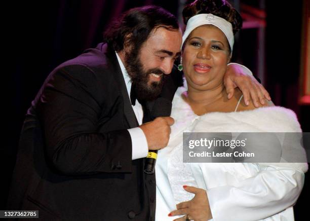 Italian operatic tenor Luciano Pavarotti hugs American singer, songwriter, and pianist Aretha Franklin during the 1998 MusiCares benefit dinner on...