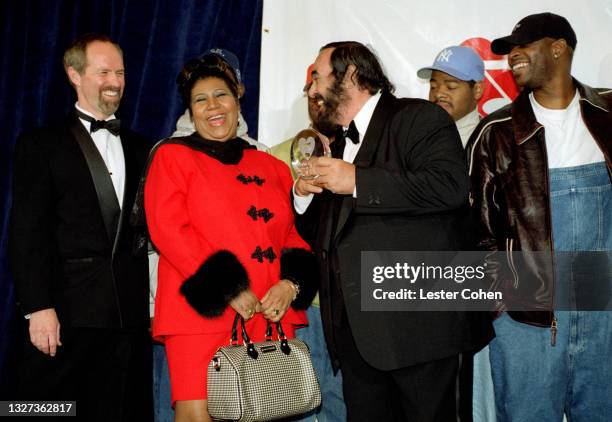 Italian operatic tenor Luciano Pavarotti stands on stage with Michael Green, American singer, songwriter, and pianist Aretha Franklin , Shawn...