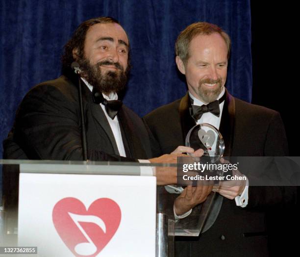 Italian operatic tenor Luciano Pavarotti receives a trophy from Michael Green at the 1998 MusiCares benefit dinner on February 23, 1998 in New York,...