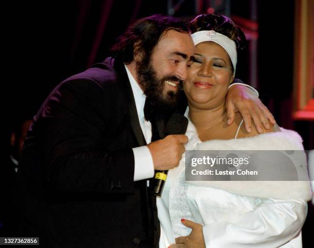 Italian operatic tenor Luciano Pavarotti hugs American singer, songwriter, and pianist Aretha Franklin during the 1998 MusiCares benefit dinner on...