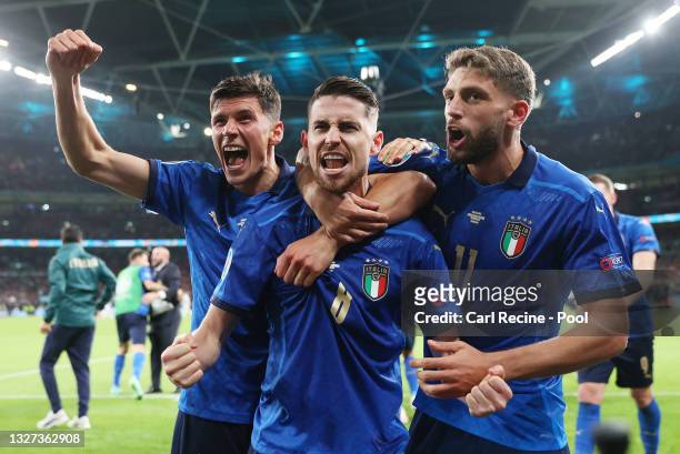 Jorginho of Italy celebrates with Matteo Pessina and Domenico Berardi after scoring their sides winning penalty in the penalty shoot out during the...