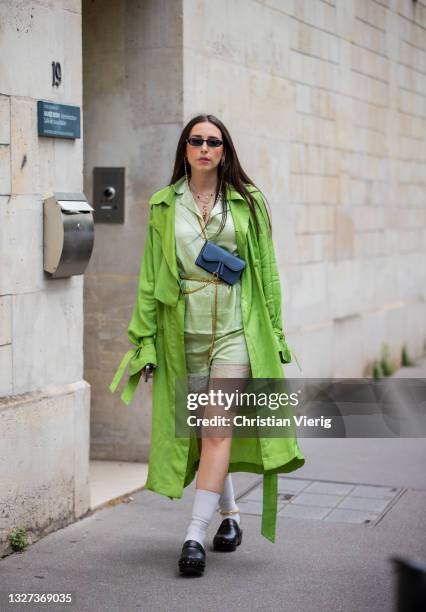 Guest is seen wearing green coat, Dior bag in blueoutside Dior on July 05, 2021 in Paris, France.