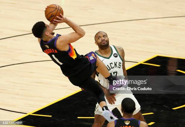 Devin Booker of the Phoenix Suns is fouled by P.J. Tucker of the Milwaukee Bucks during the first half in Game One of the NBA Finals at Phoenix Suns...