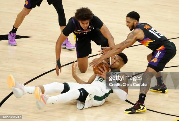 Giannis Antetokounmpo of the Milwaukee Bucks looses the ball against Cameron Payne of the Phoenix Suns during the second half in Game One of the NBA...