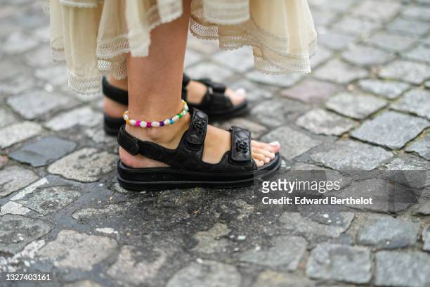 Gabriella Berdugo wears a long silk ruffled with lace long dress, a pearls and multicolored foot bracelet, black shiny leather Chanel dad shoes /...