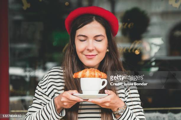 young woman with croissant - people eating in bistro stockfoto's en -beelden