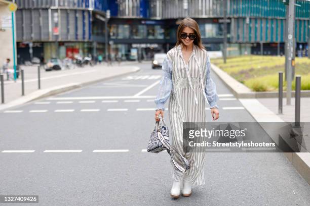 Influencer Sarah Lou Falk wearing a cream colored maxi dress with black pin stripes and light blue long sleeves with gathered detail by Munthe, brown...