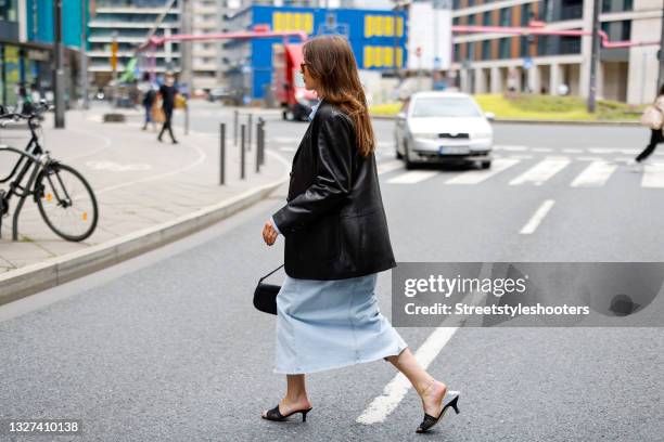 Influencer Sarah Lou Falk wearing a black leather blazer by Tory Burch, a light blue denim jeans blouse by Edited, a light blue denim jeans maxi...
