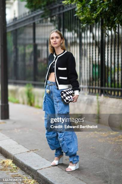 Pernille Teisbaek wears silver pearls earrings from Chanel, black crop-top, a black with white borders Chanel cardigan, a black and white checkered...