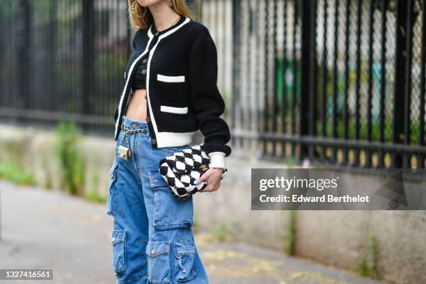 Pernille Teisbaek wears silver pearls earrings from Chanel, black crop-top, a black with white borders Chanel cardigan, a black and white checkered...