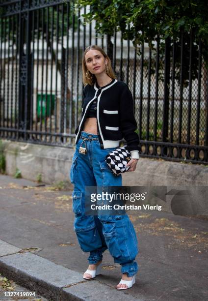 Pernille Teisbaek is seen wearing denim jeans with pockets, cardigan, checkered Chanel bag, heels, micro bag outside Chanel on July 06, 2021 in...