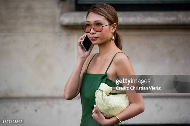 Guest is seen talking on wearing Bottega Veneta bag green dress outside Armani on July 06, 2021 in Paris, France.