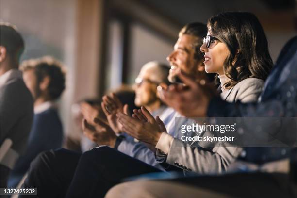 glückliche geschäftsfrau und ihre kollegen applaudieren bei einer bildungsveranstaltung im sitzungssaal. - conference centre stock-fotos und bilder