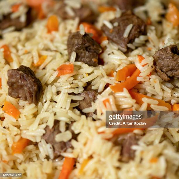 close up of wonderful uzbek pilaf. food background or texture with rice and meat dish. soft focus - pilau rice - fotografias e filmes do acervo