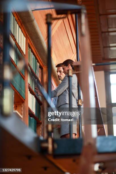 couple searching for a book in public library - law student stock pictures, royalty-free photos & images