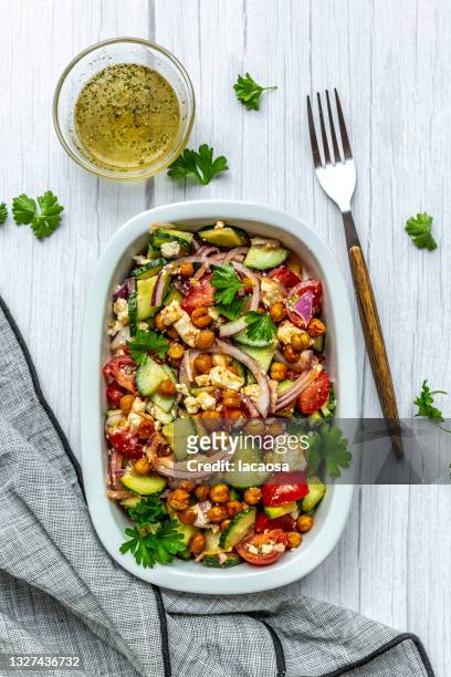 bowl of vegetarian salad with chick-peas, cucumber, tomatoes, feta and onion - chick pea salad stock pictures, royalty-free photos & images