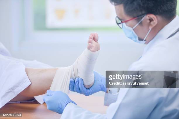 doctor bandaging a patient's foot - elastic bandage stock pictures, royalty-free photos & images