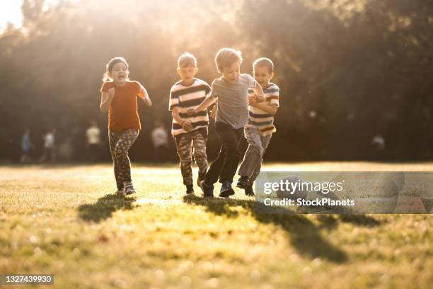 children playing soccer on the meadow - european spring bildbanksfoton och bilder