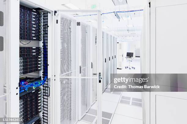medium shot of data center with door open to server rack - server di rete foto e immagini stock