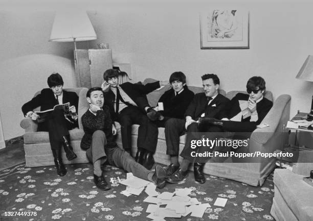 English pop group The Beatles seated with members of the press in the band's suite at the George V Hotel in Paris in January 1964. From left, Paul...