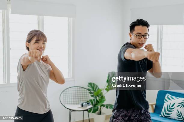 asian chinese couple doing boxing exercise at home - punching imagens e fotografias de stock