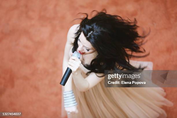 young beautiful woman singing song into microphone - singer songwriter stockfoto's en -beelden