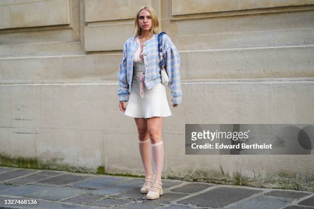 Guest wears earrings, gold chain pendant necklace, a pale pink silk shirt, a white ripped corset, a white and blue houndstooth pattern tweed jacket,...