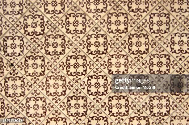 beige ceramic wall tiles with brown curlicue and stylished clover leaf pattern - mexican flower pattern stock-fotos und bilder