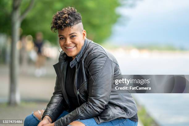 mujer afroamericana sonriente en la ciudad - corte de pelo con media cabeza rapada fotografías e imágenes de stock