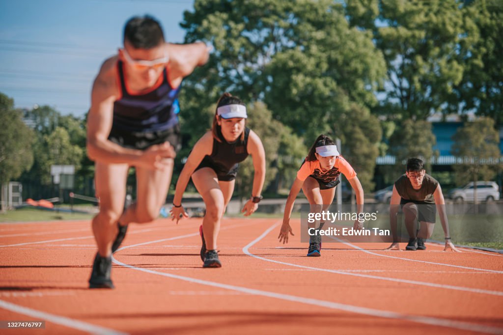 Asian chinese young athletes sprint running at track and run towards finishing line in the morning at track and field stadium