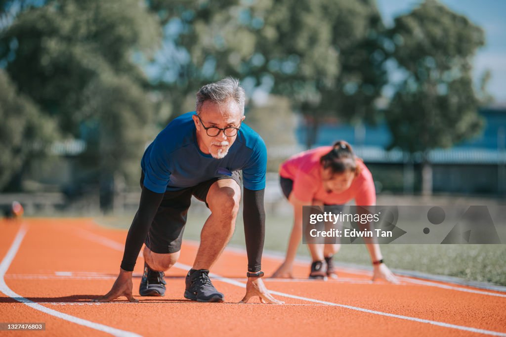 Asiatische chinesische Senior Paar immer bereit, im Leichtathletik-Stadion am Morgen zu sprinten
