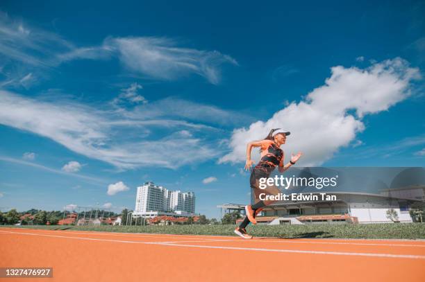 asiatische chinesische athletinnen sprinten auf der bahn und laufen morgens im leichtathletikstadion in richtung ziellinie - leichtathletikstadion stock-fotos und bilder