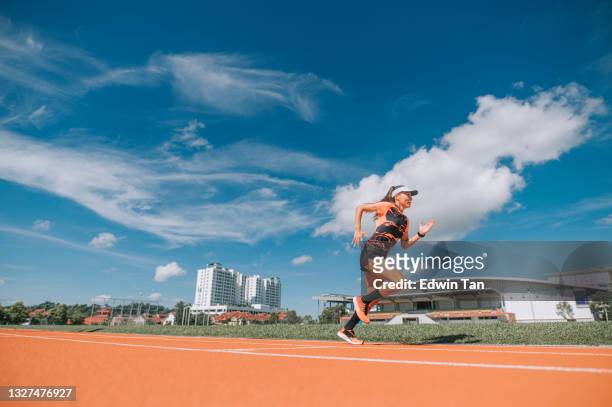 atletas asiáticas chinas corren corriendo en pista y corren hacia la línea de meta por la mañana en el estadio de atletismo - estadio de atletismo fotografías e imágenes de stock