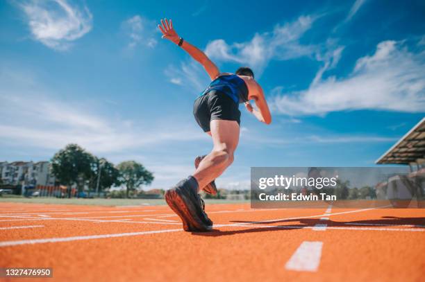 rear view aerodynamic asian chinese male athletes sprint running at track and run towards finishing line in the morning at track and field stadium - asian calves stockfoto's en -beelden