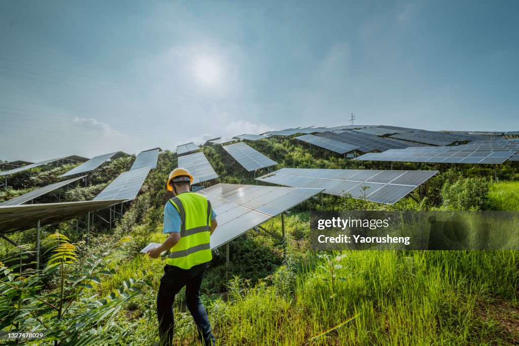 One person checking the solar panel with digital tools