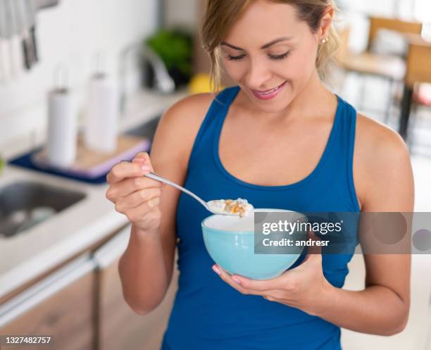 healthy eating woman having a bowl of cereals for breakfast - adult eating cereal stock pictures, royalty-free photos & images