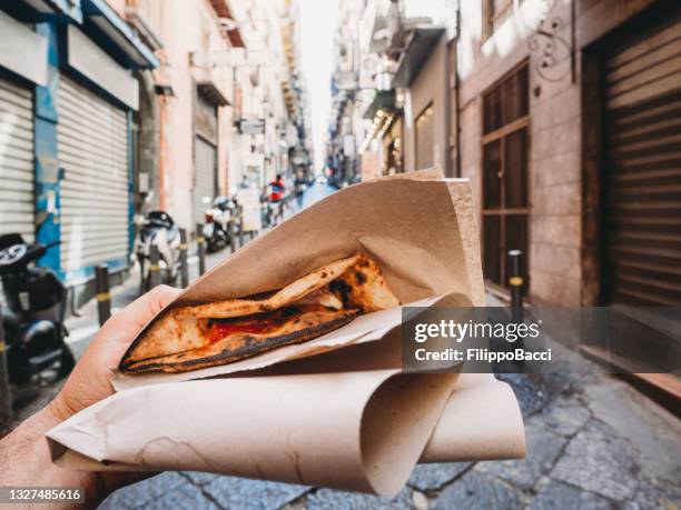 pov view of a man eating a typical "pizza a portafoglio" in naples, italy - folded hands stock pictures, royalty-free photos & images