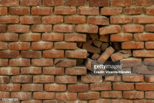 crumbling brick wall - brick wall hole stock pictures, royalty-free photos & images