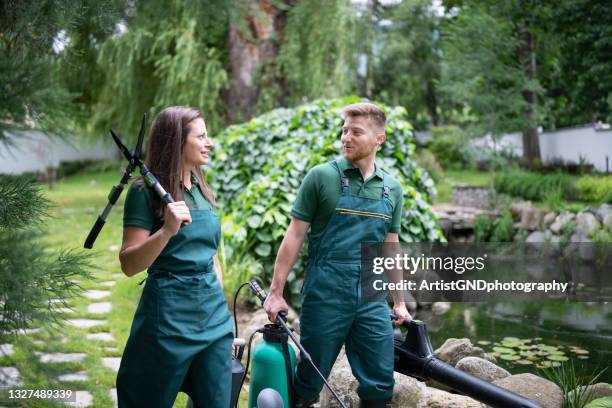 equipo de paisajismo profesional que trabaja en garden. - ajardinado fotografías e imágenes de stock