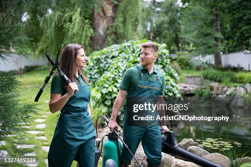 Professional Landscaping Team Working In Garden. Professional Landscaping Team Working In Garden.