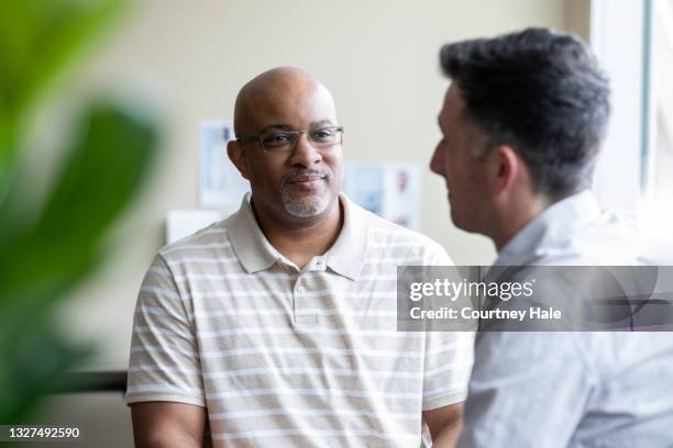 mature man listens to therapist during counseling session - male patient stock pictures, royalty-free photos & images